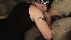 The Hot Stud Sits Comfortably On The Couch While A Horny Dude Blows His Big Cock